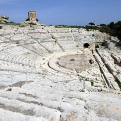 “No! Al Teatro Greco no!” grida il prof. Aristogitone dai gradini di 2.300 anni
